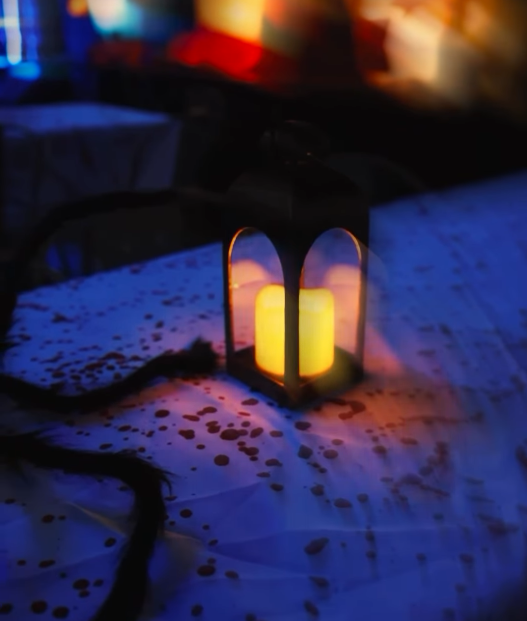 Candle lantern on a blood-spattered tablecloth at the Playground Dropout Halloween Pop-Up Bar